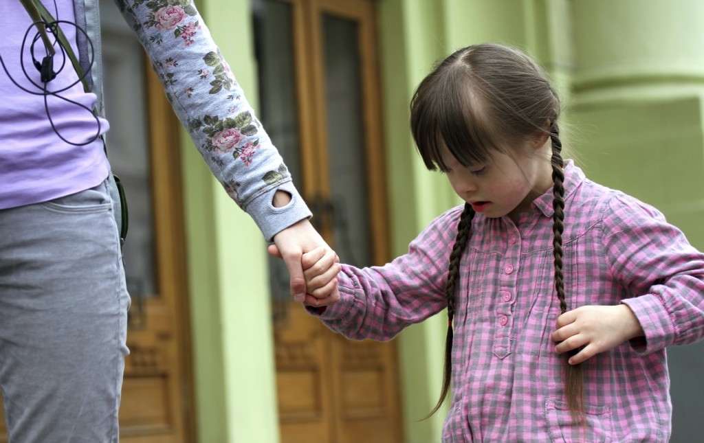 Girl holding arms of the mother on a walk .